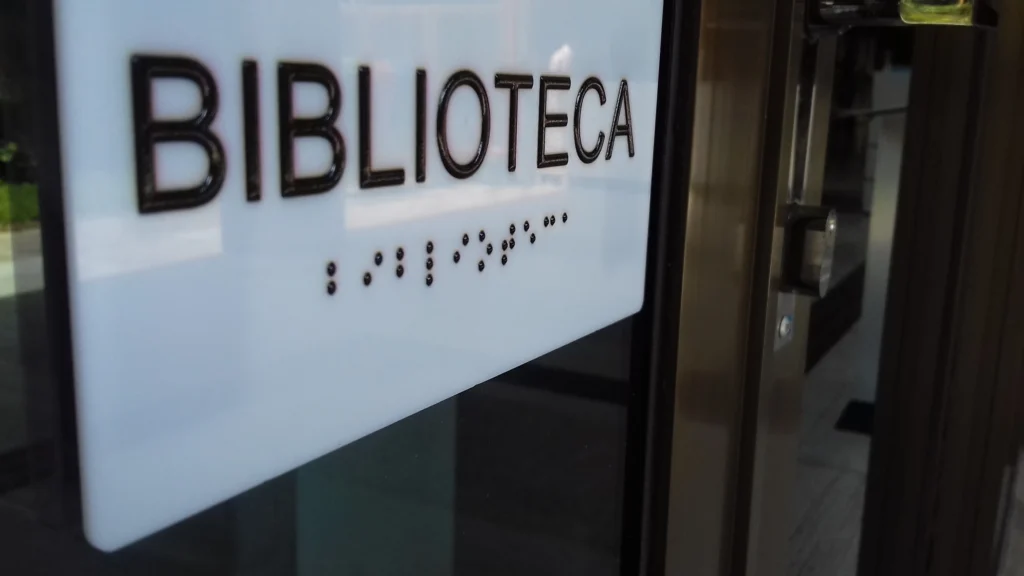 Placa em braile instalada na porta de uma biblioteca