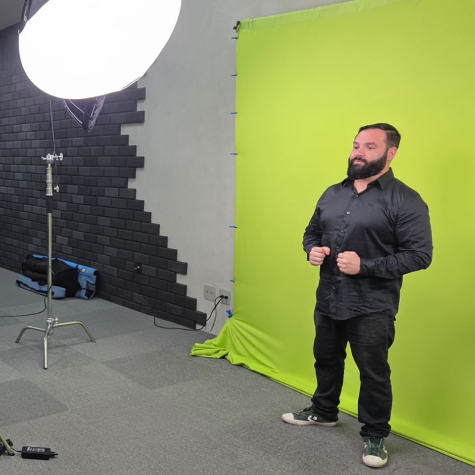 Janela de Libras: homem posicionado em frente a câmera com fundo verde.